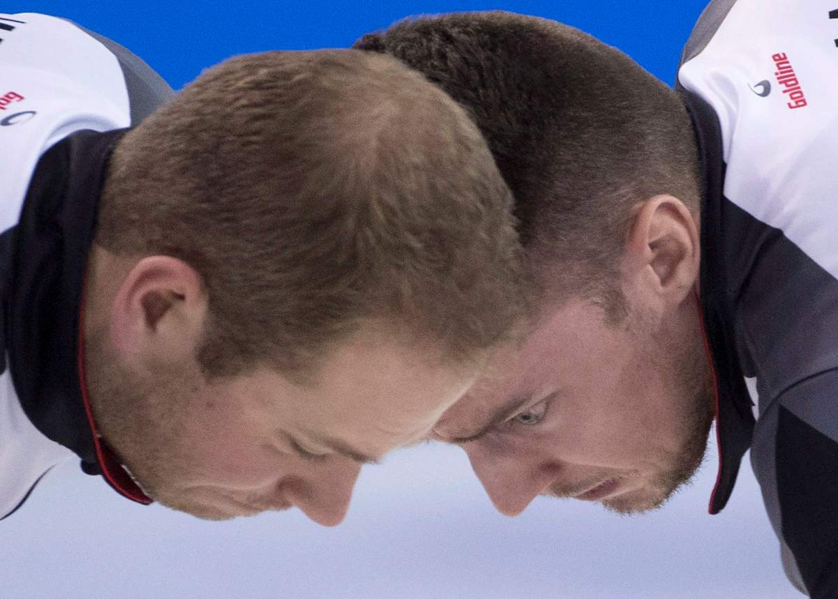 Canada lead Geoff Walker, left, and second Brett Gallant sweep during the 10th draw against China at the Men’s World Curling Championships in Edmonton, Tuesday, April 4, 2017. THE CANADIAN PRESS/Jonathan Hayward