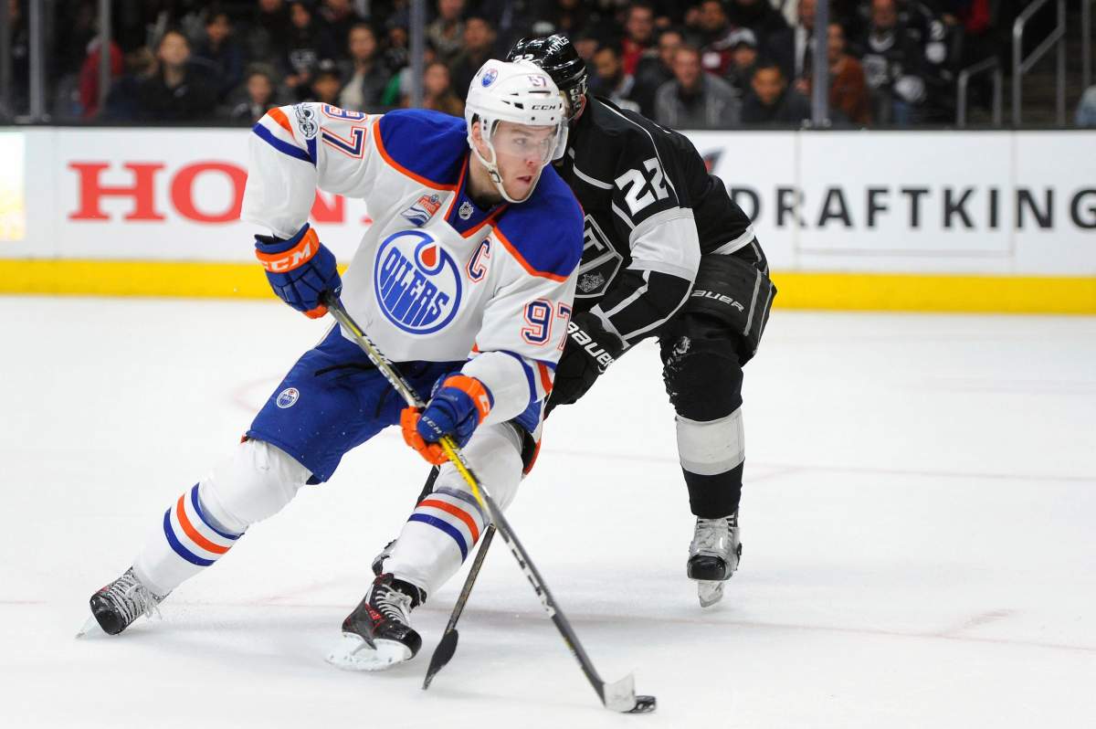 Edmonton Oilers center Connor McDavid (97) advances the puck as Los Angeles Kings center Trevor Lewis (22) defends in the third period of an NHL hockey game, Tuesday, April 4, 2017, in Los Angeles. The Kings won 6-4.