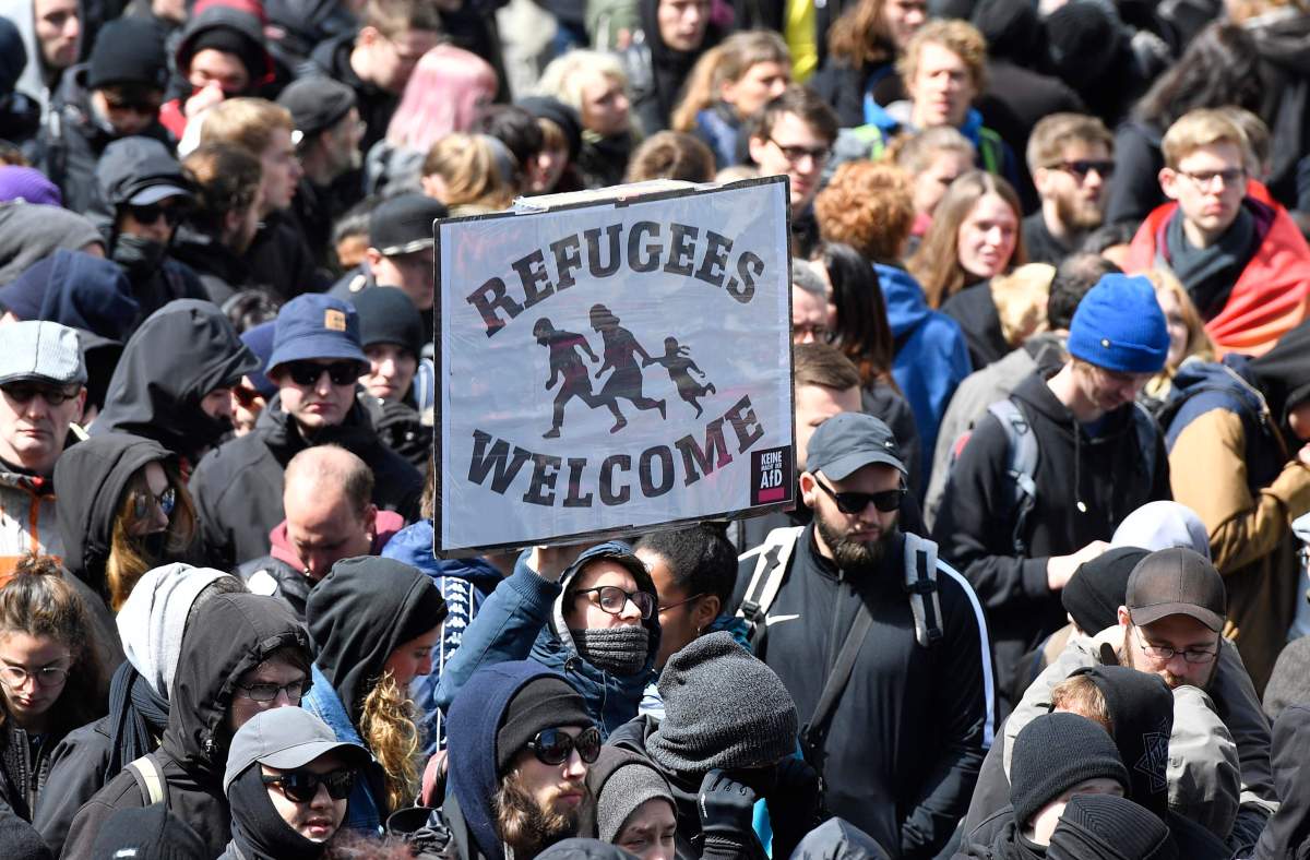 Protestors hold a banner reading 'refugees welcome' during a demonstration against the party convention of Germany's nationalist party AfD (Alternative for Germany) in Cologne, Germany, Saturday, April 22, 2017.