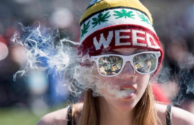 A woman exhales while smoking a joint during the annual 420 marijuana rally on Parliament hill on Wednesday, April 20, 2016 in Ottawa.