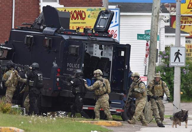 Emergency response officers enter a residence in Moncton, N.B. on Thursday, June 5, 2014. Three years after a gunman's rampage left three Mounties dead, the RCMP itself faces trial Monday.The Labour Code trial stems from the force's response to the 2014 massacre in Moncton, N.B., and the wife of one victim says it will be emotional for her - but necessary.
