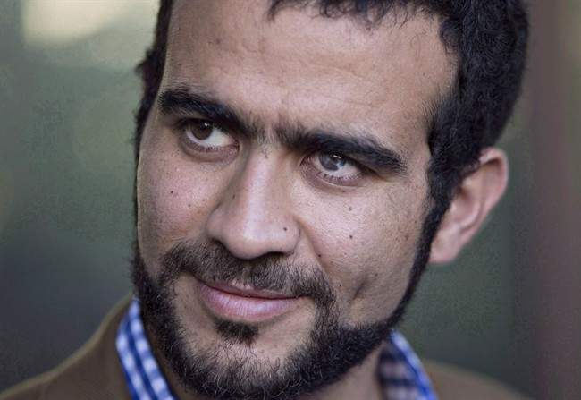 Omar Khadr watches as his lawyer Dennis Edney speaks to media after his bail conditions hearing in Edmonton on Friday, September 11, 2015.