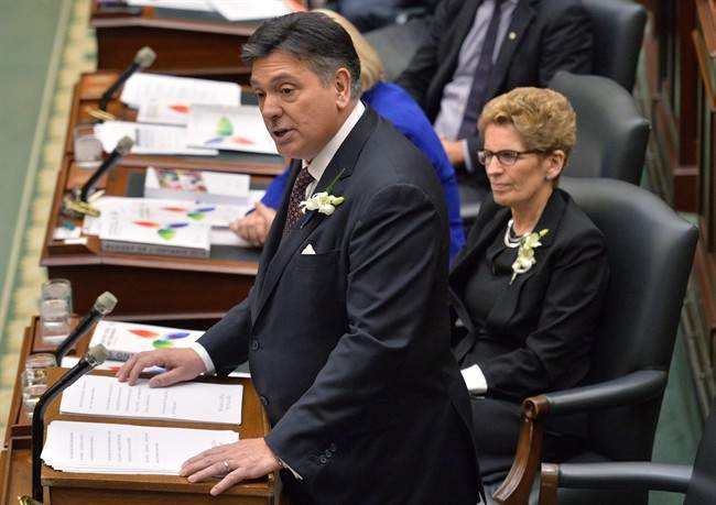 Ontario Finance Minister Charles Sousa, left, delivers the Ontario 2016 budget next to Premier Kathleen Wynne, right, at Queen's Park in Toronto on Thursday, February 25, 2016.