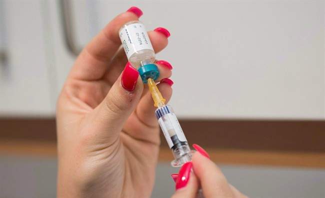 A doctor's assistant prepares a measles vaccination.