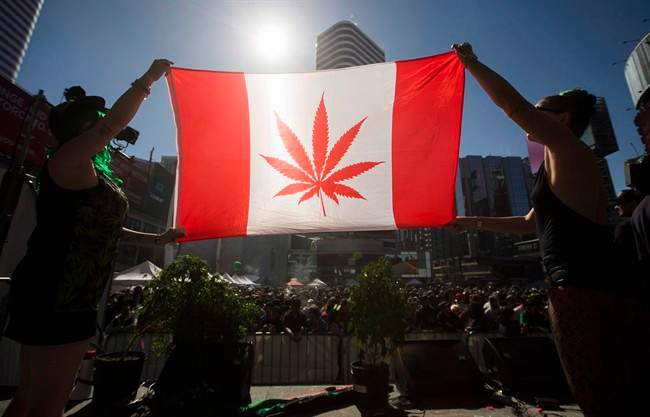 Two people hold a modified design of the Canadian flag with a marijuana leaf in place of the maple leaf during the "420 Toronto" rally in Toronto, April 20, 2016.