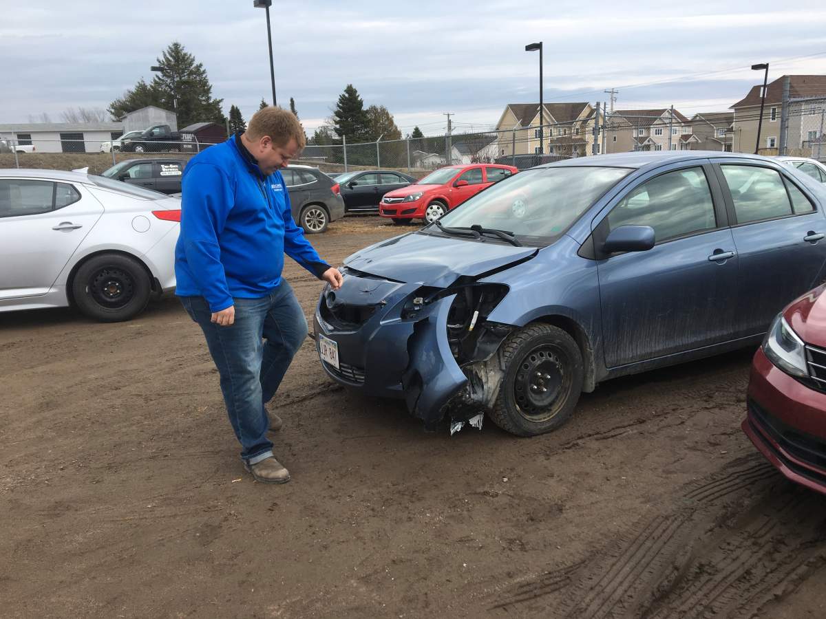 Andrew Barkhouse picks deer hair our of the front of a damaged car