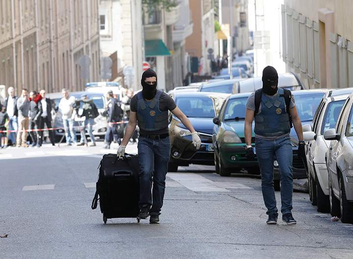 An Elite police officer pulls a suitcase after searches in Marseille, southern France, Tuesday, April 18, 2017. 