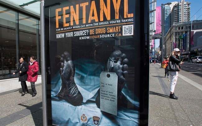 An anti-fentanyl advertisment is seen on a sidewalk in downtown Vancouver, Tuesday, April, 11, 2017. A tag hanging from a dead man's left toe says the cause of death was an overdose of fentanyl, "unknowingly taken with other drugs." The cadaver draped in a white sheet is displayed in transit ads funded by the Vancouver Police Foundation and represents 922 people who died in British Columbia from drug overdoses last year alone. 
