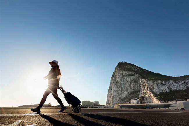 A woman walks on the Spanish side of the border between Spain and the British overseas territory of Gibraltar, on Wednesday, March 1, with the iconic Rock of Gibraltar in the background, in La Linea de la Concepcion, Southern Spain.