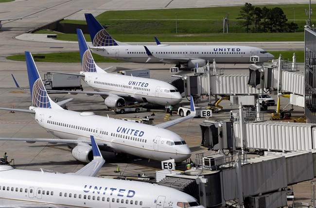 In this July 8, 2015, file photo, United Airlines planes are parked at their gates as another plane, top, taxis past them at George Bush Intercontinental Airport in Houston.