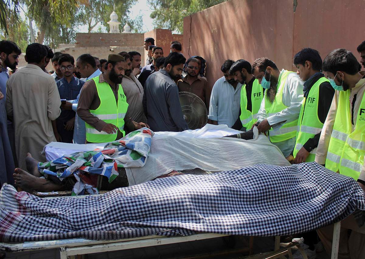 Pakistani volunteers and local residents gather around the bodies of people who were killed in a local shrine, outside the morgue of a hospital in Sarghodha, Pakistan, Sunday, April 2, 2017. 