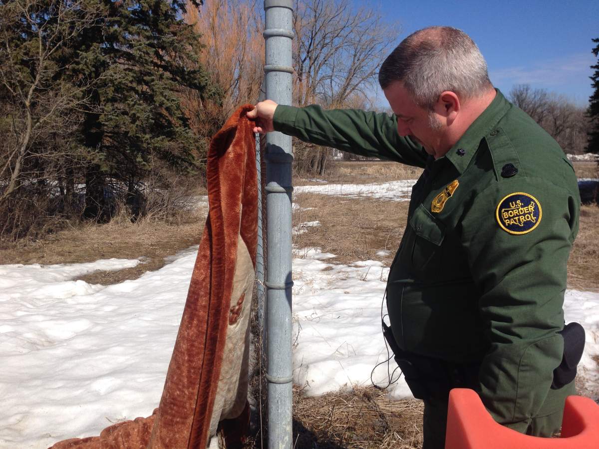 Sgt. Webster holds a blanket left behind by asylum seekers in Noyes Minn.