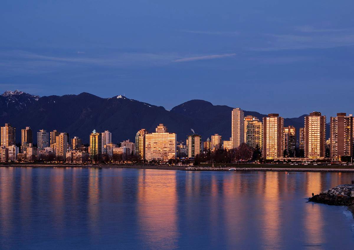 A colourful sunset is reflected in English Bay by the high-rise buildings of Vancouver's West End district, January 5, 2014. 