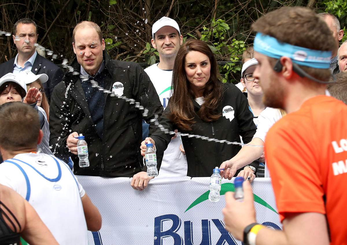 A runner squirts water towards Britain's Prince William, the Duke of Cambridge, as he hands out water to runners during the London Marathon in London, Sunday, April 23, 2017. 