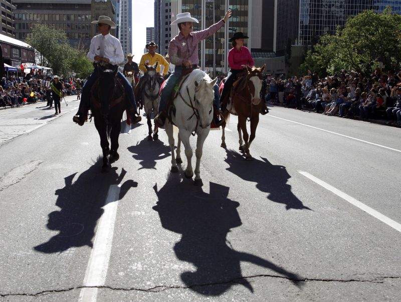 Calgary Stampede parade marshal and astronaut Chris Hadfield, centre, waves to the crowds during the Calgary Stampede parade in Calgary, Friday, July 5, 2013.