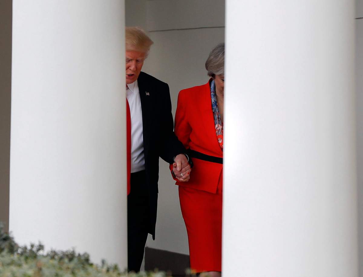 In this Jan. 27, 2017, file photo, President Donald Trump holds British Prime Minister Theresa May\’s hand as they walk along the colonnade of the White House in Washington.