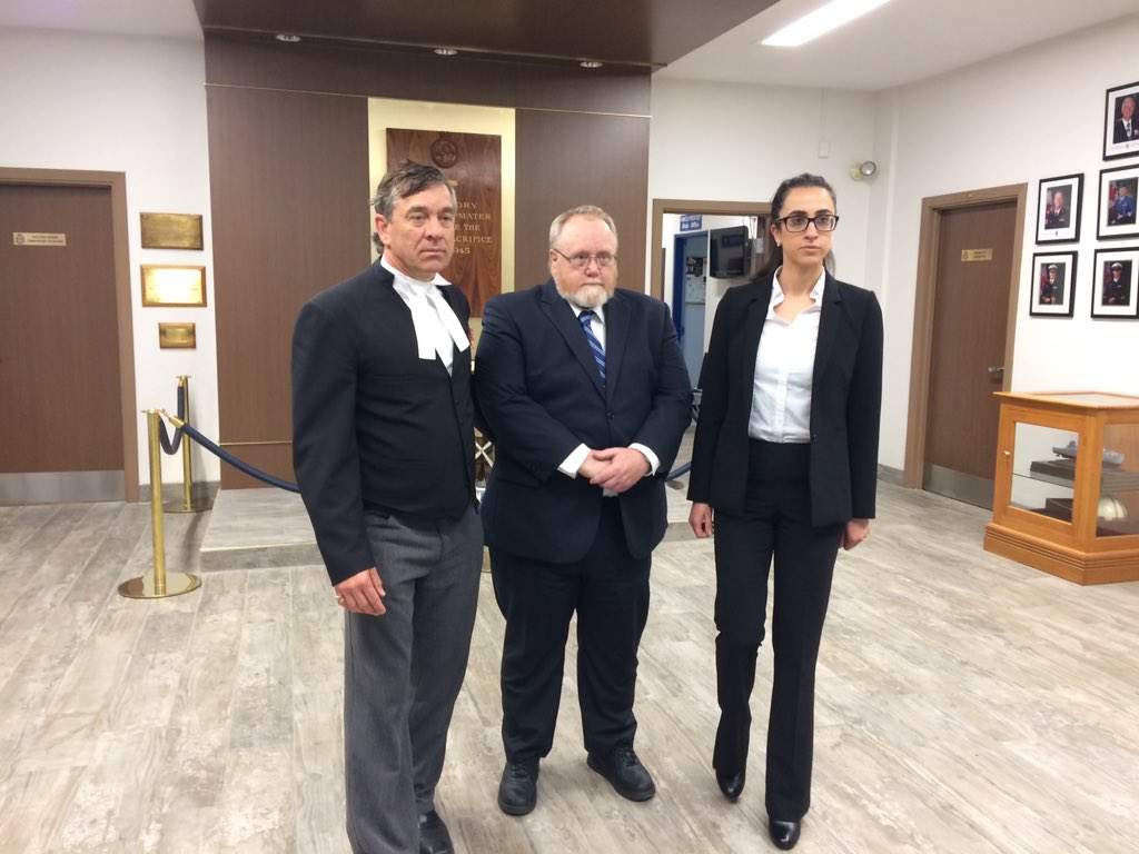 Former military medic James Wilks stands with his defence counsel at HMCS Prevost, London, on May 25, 2017.