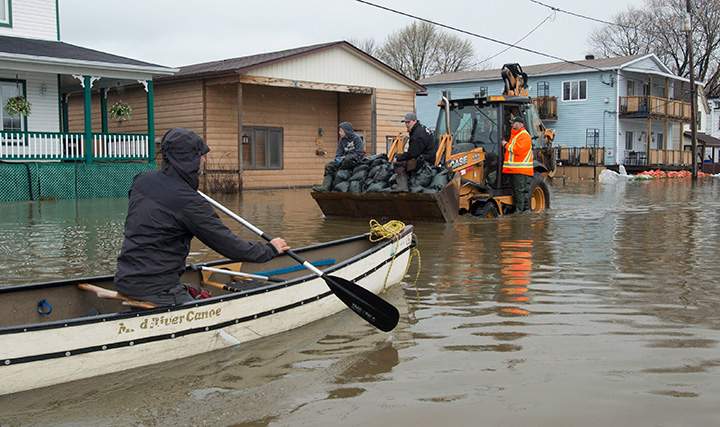 Automobile traffic was replaced by boats and heavy equipment carrying sandbags as flood waters continued to rise Sunday May 7, 2017 in Gatineau, Que.
