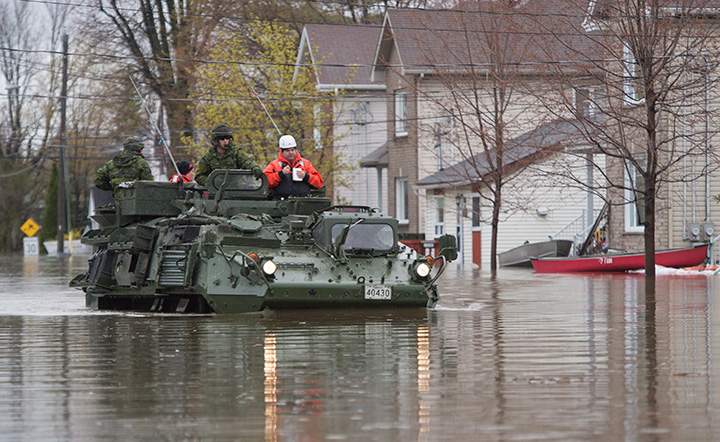 A military vehicle drives along a flooded street Sunday May 7, 2017 in Gatineau, Que.