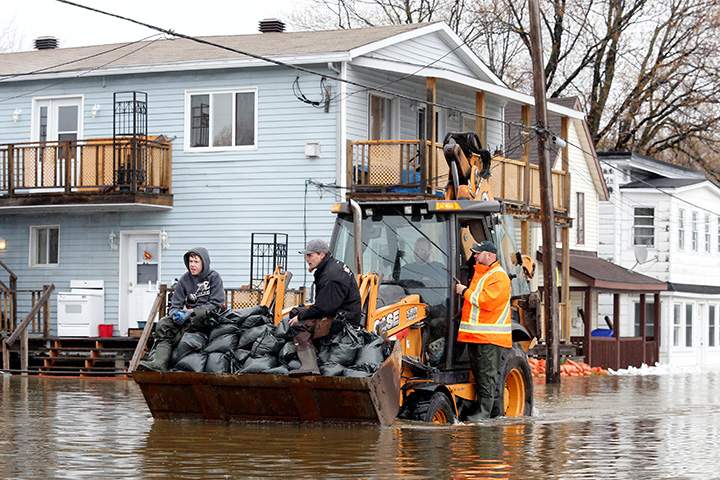 Residents transport sandbags to a home in a flooded residential area in Gatineau, Quebec, May 7, 2017.