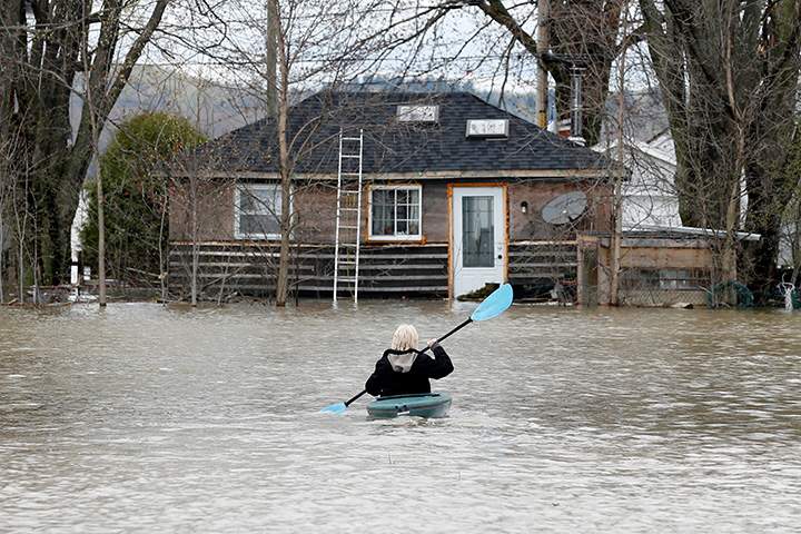A woman kayaks in a flooded residential area in Rigaud, Quebec, May 6, 2017.