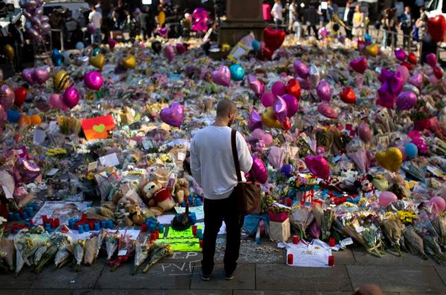 A man stands next to flowers for the victims of the Manchester bombing after an Ariana Grande concert. Urban terrorism will be discussed on the Roy Green Show.