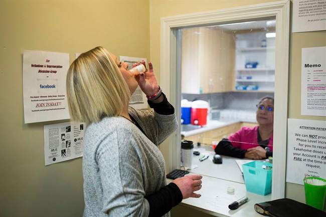 A person in addiction treatment takes a dose of methadone.
