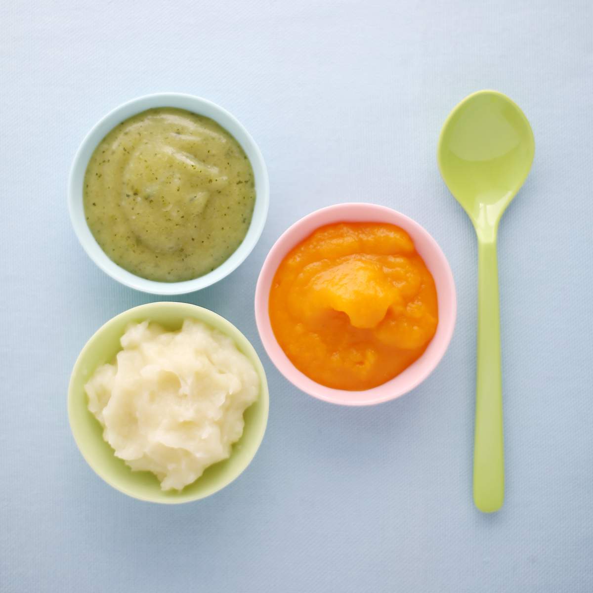 Close-up of vegetables mashes in baby bowls.