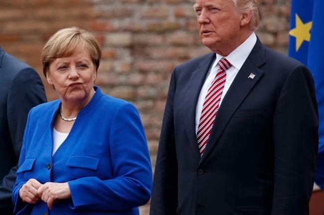 German Chancellor Angela Merkel and President Donald Trump pose for a family photo with G7 leaders at the Ancient Greek Theater of Taormina, Friday, May 26, 2017, in Taormina, Italy. 