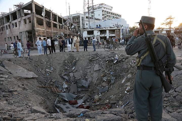 Security forces stand next to a crater created by massive explosion in front of the German Embassy in Kabul, Afghanistan, Wednesday, May 31, 2017.