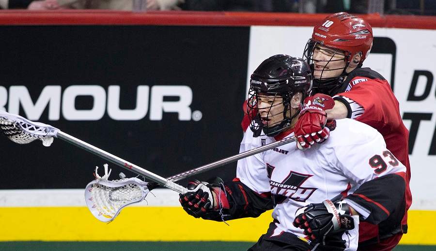 Calgary Roughnecks' Curtis Manning, right, wraps his stick around Vancouver Stealth's Johnny Powless during NLL lacrosse action in Calgary, Alberta on Saturday, Feb. 21, 2015.
