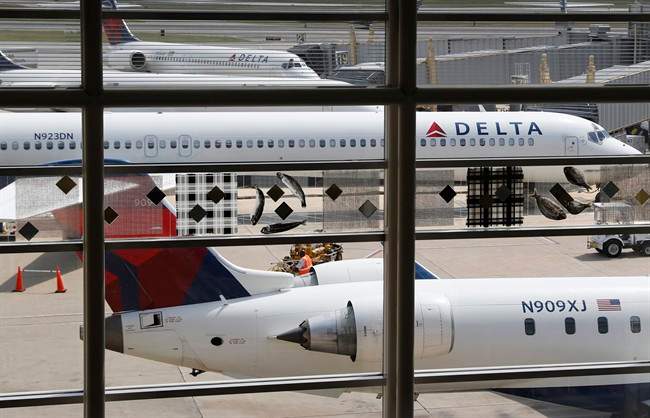 FILE – In this Monday, Aug. 8, 2016, file photo, Delta Air Lines planes are parked at Ronald Reagan Washington National Airport, in Washington.