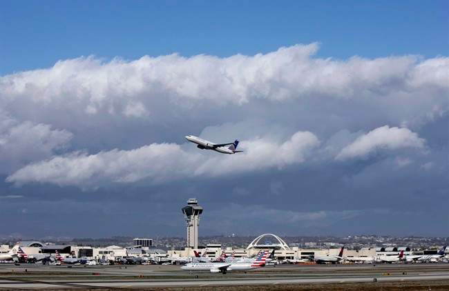 A plane flies over Los Angeles airport in a file photo. Canadian Chaoyi Le was taken into custody Friday after getting off a flight from Shanghai.