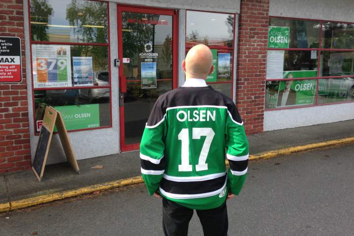 Sporting a Green Party hockey jersey, Saanich North candidate Adam Olsen stands outside his campaign office in Sidney.