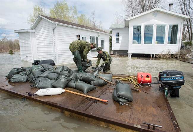 Soldiers build a dam with sandbags around a flooded house on the shores of Lake St-Pierre in Yamachiche, Que. on Thursday, May 11, 2017. The annual costs for natural disaster response in Canada is climbing.