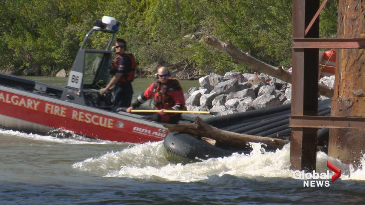 A Calgary Fire crew works to free a raft that got stuck on the Zoo Bridge in the Bow River on Sunday. 