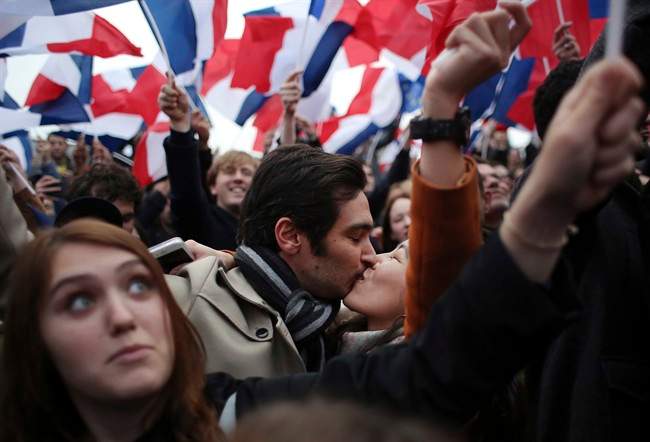 Supporters of French independent centrist presidential candidate, Emmanuel Macron kiss as they celebrate outside the Louvre museum in Paris, France, Sunday, May 7, 2017. 