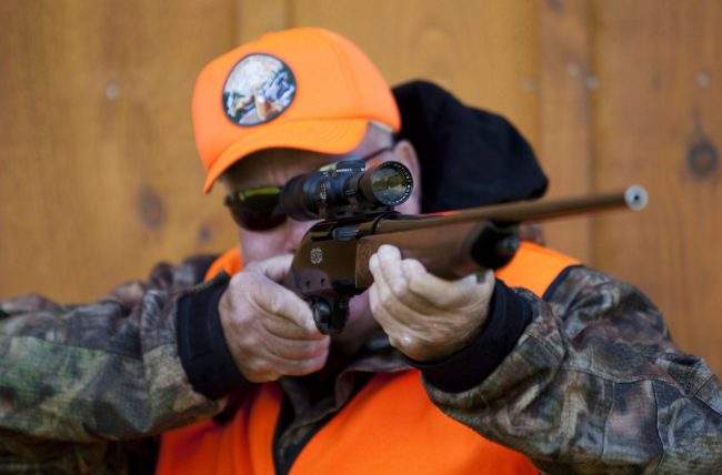 A rifle owner checks the sight of his rifle at a hunting camp property in rural Ontario west of Ottawa, Sept. 15, 2010. 
