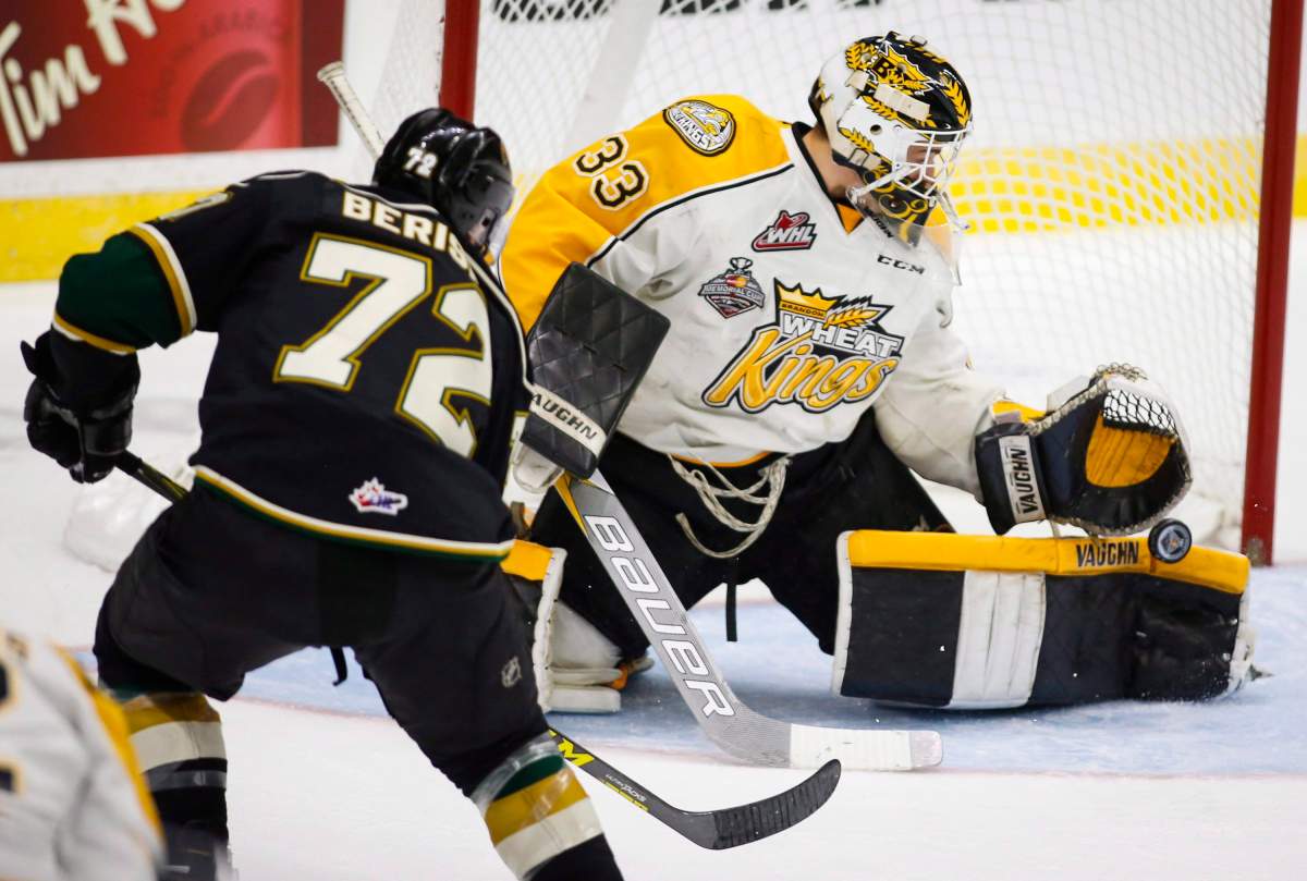 London Knights' Aaron Berisha, left, has his shot stopped by Brandon Wheat Kings goalie Jordan Papirny.