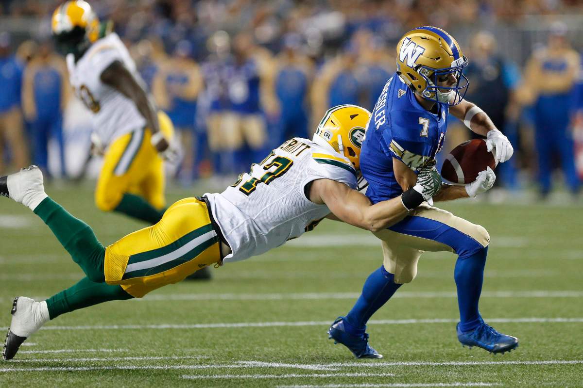 Edmonton Eskimos' JC Sherritt (47) strips the ball from the hands of Winnipeg Blue Bombers' Weston Dressler (7) during the first half of CFL action in Winnipeg Friday, September 30, 2016. 
