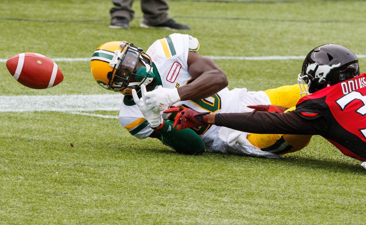 Edmonton Eskimos Bryant Mitchell (80) fumbles a catch in the endzone under pressure from Calgary Stampeders Osagie Odiase (32) during first half CFL pre-season action in Edmonton, Alta., on Sunday June 11, 2017. THE CANADIAN PRESS/Amber Bracken.
