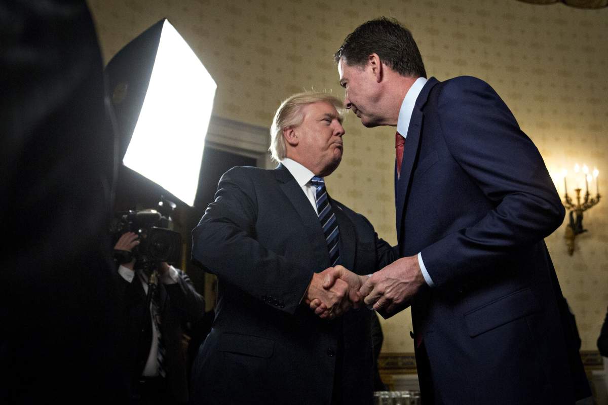 United States President Donald J. Trump, left, shakes hands with James Comey, director of the Federal Bureau of Investigation (FBI) in the Blue Room of the White House on Jan. 22, 2017.