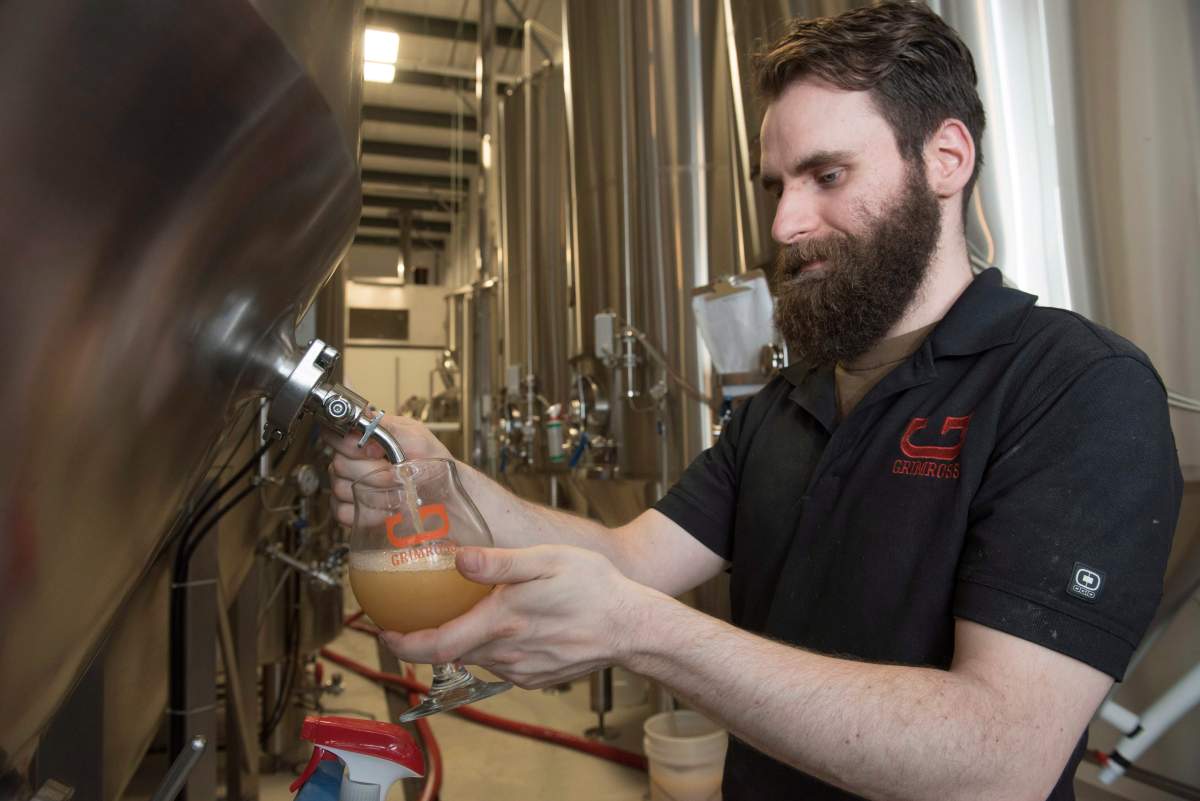 Ben Ellick, Brewer at Grimross Craft Brewing, checks a new batch at their business in Fredericton, N.B., on Friday, June 16, 2017. The craft brewing industry is booming in Fredericton and officials in New Brunswick’s capital are hoping tourists will want to taste what the city has on tap.
