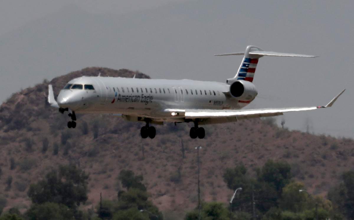 An American Eagle jet is seen through heat ripples as it lands at Sky Harbor International Airport, Monday, June 19, 2017 ,in Phoenix. American Airlines cancelled dozens flights out of Phoenix today due to extreme heat. The cancellations are for operations by smaller regional jets that have lower maximum operating temperatures than full size jets. The smaller jets can\’t operate when it’s 118 degrees or higher.