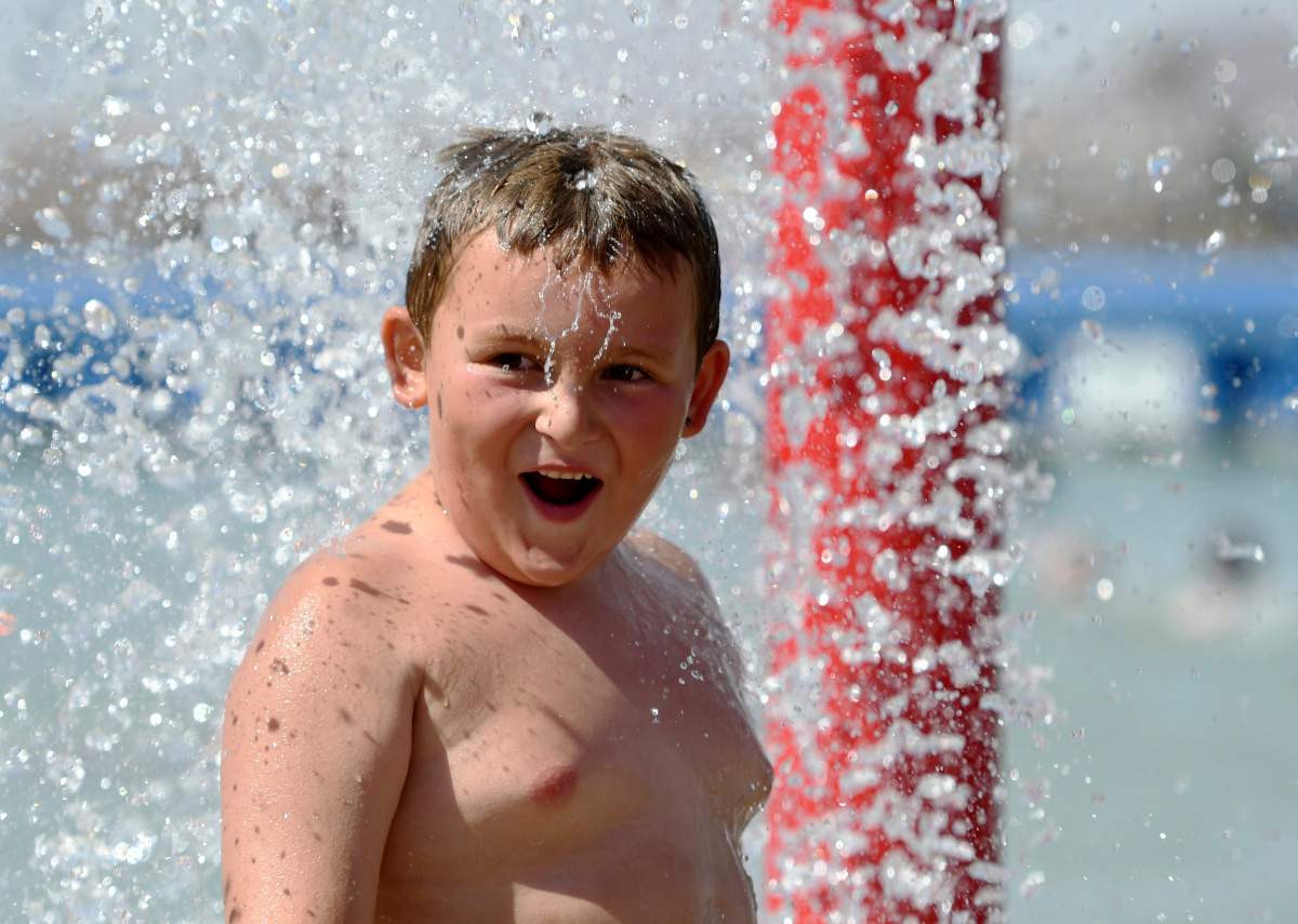 Blake Shetley grins as he’s doused with water from a fountain in Spring Valley Lake in Victorville, Calif., Monday, June 19, 2017. Airlines canceled flights in Phoenix and doctors urged people to be careful around concrete, playground equipment and vehicle interiors Monday as a punishing heat wave threatens to bring temperatures approaching 120 degrees to parts of the Southwestern U.S.