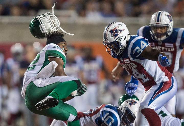 Saskatchewan Roughriders running back Cameron Marshall loses his helmet as he is rushed by Montreal Alouettes linebacker Kyries Hebert during third quarter CFL football action in Montreal on Thursday, June 22, 2017. THE CANADIAN PRESS/Paul Chiasson