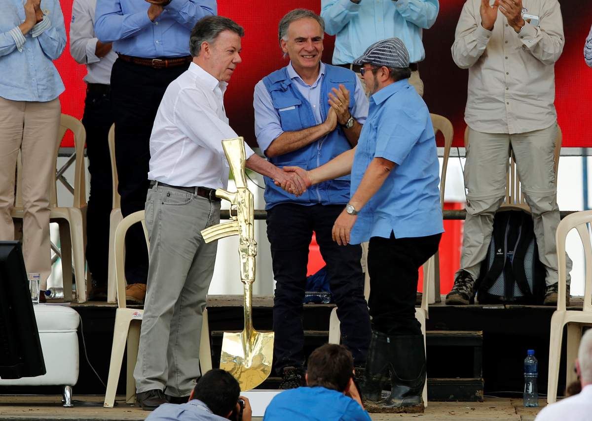 Colombia's Marxist FARC rebel leader Rodrigo Londono, also known as Timochenko, Colombian President Juan Manuel Santos and Jean Arnault, the UN Secretary-General's Special Representative for Colombia and Head of the UN Mission to Colombia, attend the final act of abandonment of arms in Mesetas, Colombia June 27, 2017. 