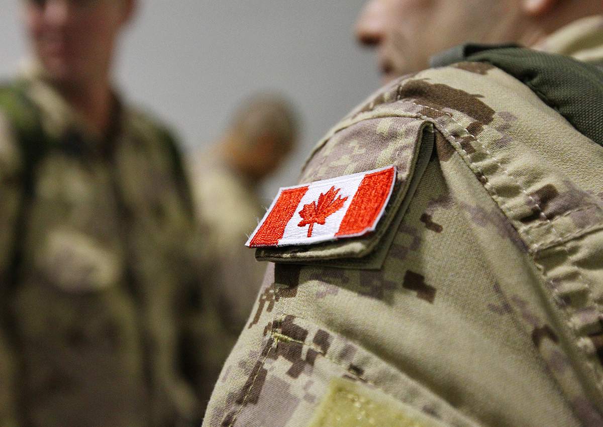 The Canadian flag is seen on the shoulder of a soldier waiting to board an Airbus CC-150 Polaris at CFB Trenton in Trenton, Ont., on Oct. 16, 2014.