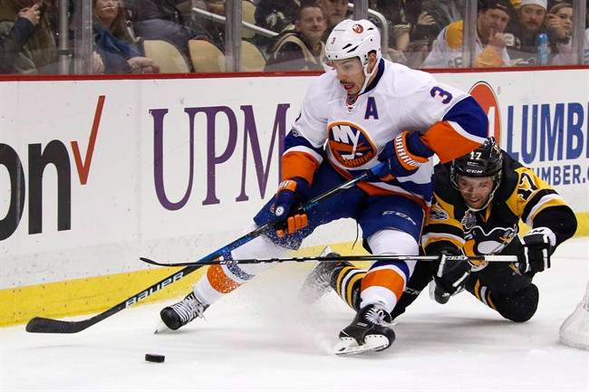 Pittsburgh Penguins' Bryan Rust (17) collides with New York Islanders' Travis Hamonic (3) during the second period of an NHL hockey game in Pittsburgh, Friday, March 24, 2017.Defenceman Hamonic was acquired by the Calgary Flames in a trade with the Islanders on Saturday.