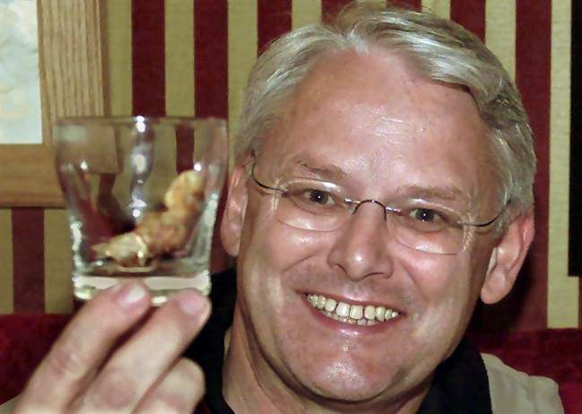 Former B.C. Premier Gordon Campbell smiles as he holds a sourtoe cocktail glass of Yukon Jack Whiskey at the Sourdough Saloon in Dawson City, Yukon, Wednesday, June 5, 2002.